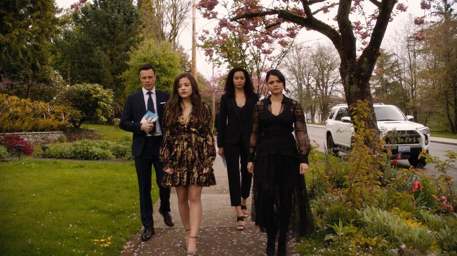 Harry, Maggie, Macy, and Mel walk down the sidewalk after Galvin's funeral.