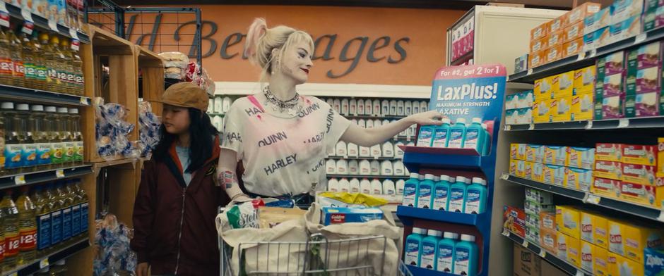 Harley grabs a bottle of laxative from a display while shopping with Cassandra.