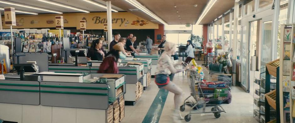 Cassandra runs after Harley as she knocks down a store employee trying to stop them from running from the store with their cart of stolen goods.