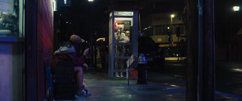 Cassandra waits while Harley talks to Roman Sionis in the phone booth.