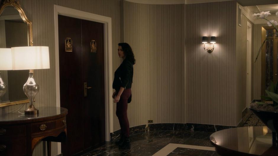 Kady approaches the door to the Balls' hotel suite.