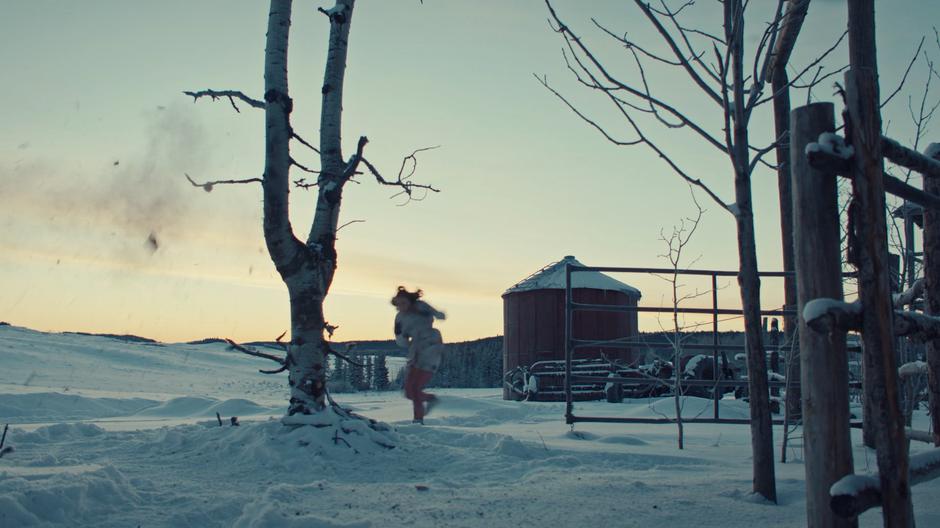 Waverly ducks down when a gunshot hits the tree next to her.