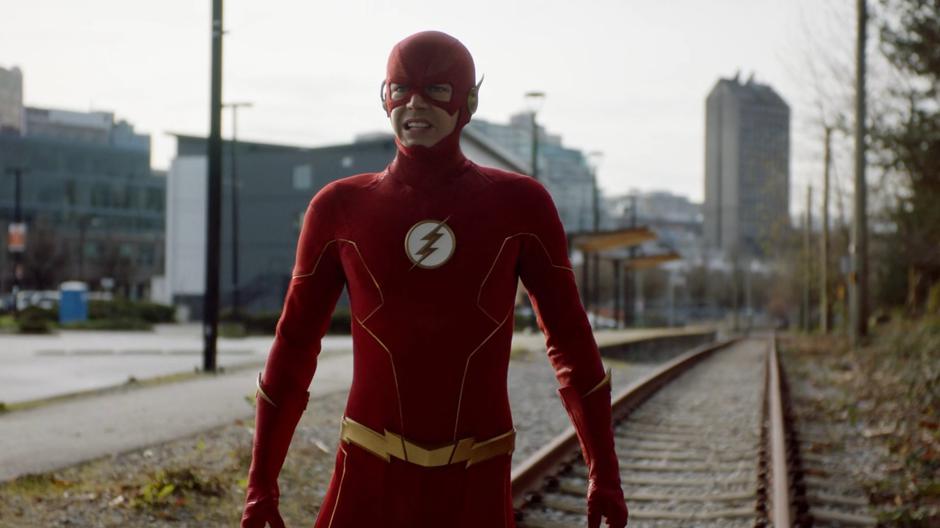 Barry stands in the middle of the tracks after phasing to avoid being hit by a train.