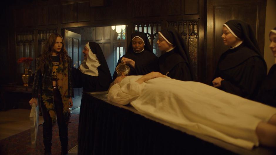 A nun shows Wynonna to a room where a woman is being prepared to be accepted into the sanctuary by a group of nuns.