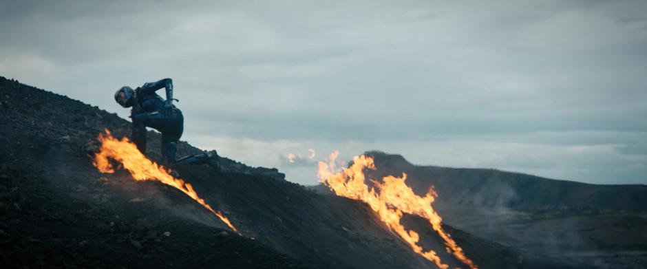 Michael struggles to stand amongst the flames of where she crashed.