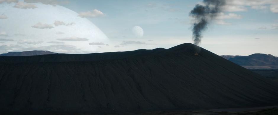Smoke rises from the side of the dark crater from where Michael crashed.