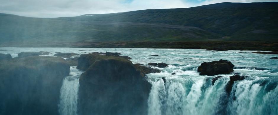 Booker and Michael walk along a small piece of ground atop a waterfall.