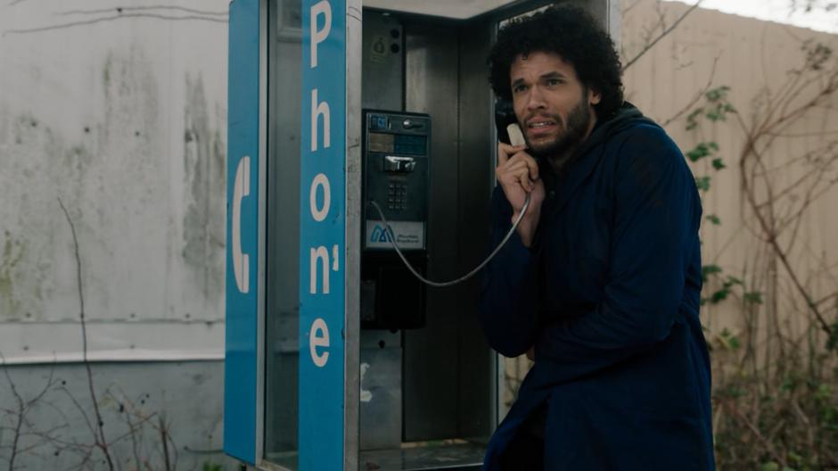 Jordan looks around while calling Maggie from a payphone.