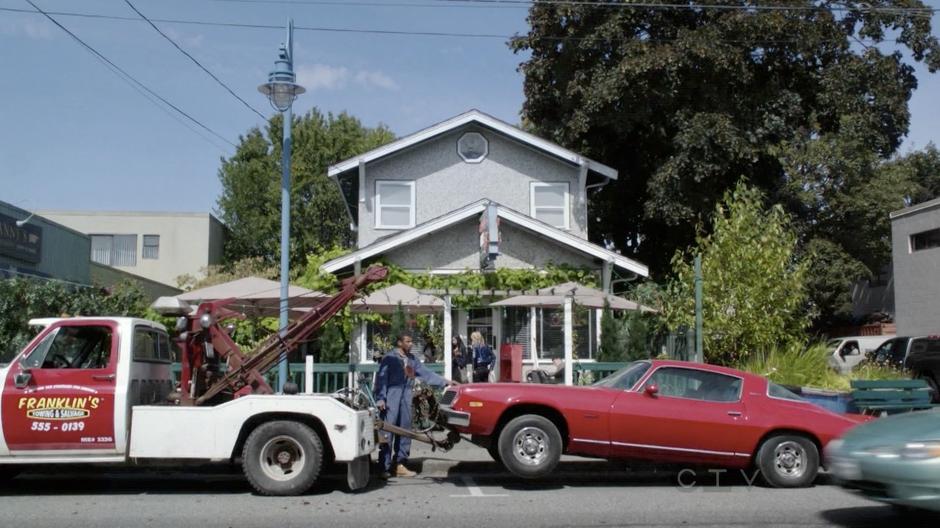 A car is dropped off by a tow truck in front of Granny's Diner.