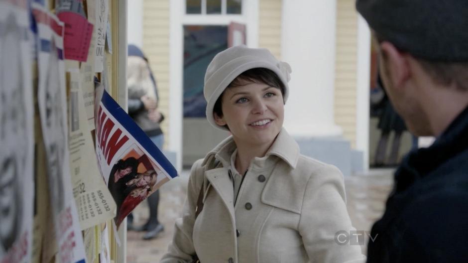 Mary Margaret talks to David while hanging up fliers for the Sheriff election.