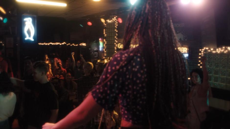 Young Macy sings in front of a bar full of people.