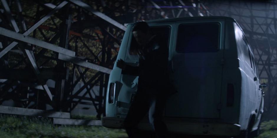 Tommy flies back against the back door of Ryan's van after she kicks him.