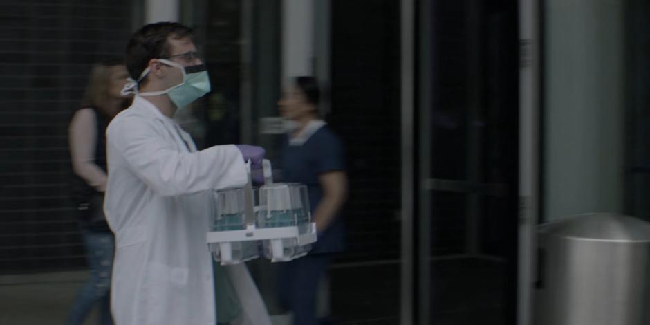 A doctor carries the cure into the hospital from the Hamilton Dynamics van.