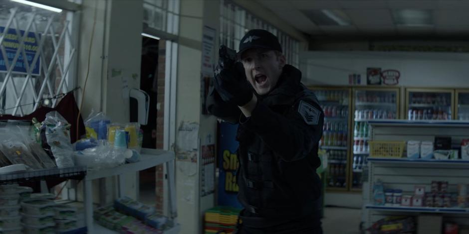 A Crows Security guard points his gun at Ryan.