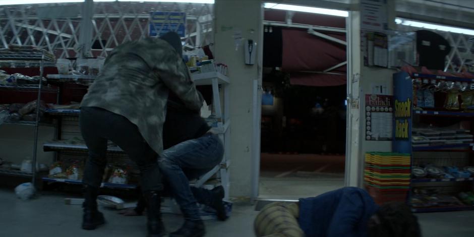 Ryan lies on the ground as the two thieves prepare to run from the store.