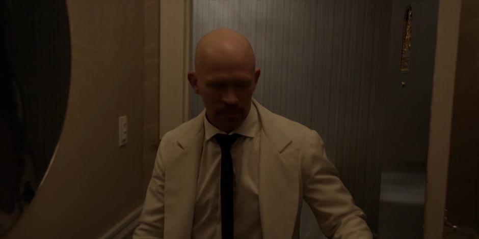 Victor Zsasz pushes his way into the hotel room.
