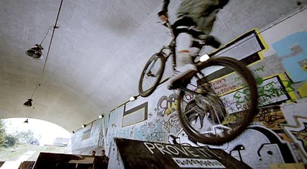 A man performs some bicycle tricks at the bike park.