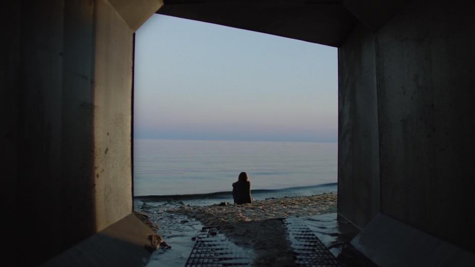 Bobby sits on the shore looking out over the water.