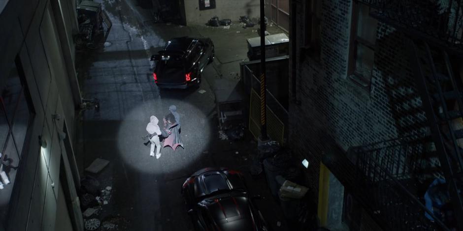 Mary and Luke carry Ryan to their car as a helicopter's spotlight shines down on them.