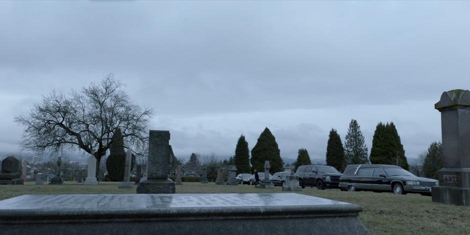 Mary walks from the cars towards Kate's grave.