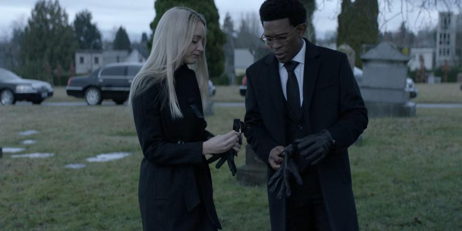 Julia pins a black ribbon on Luke's jacket before they head to the gravesite.
