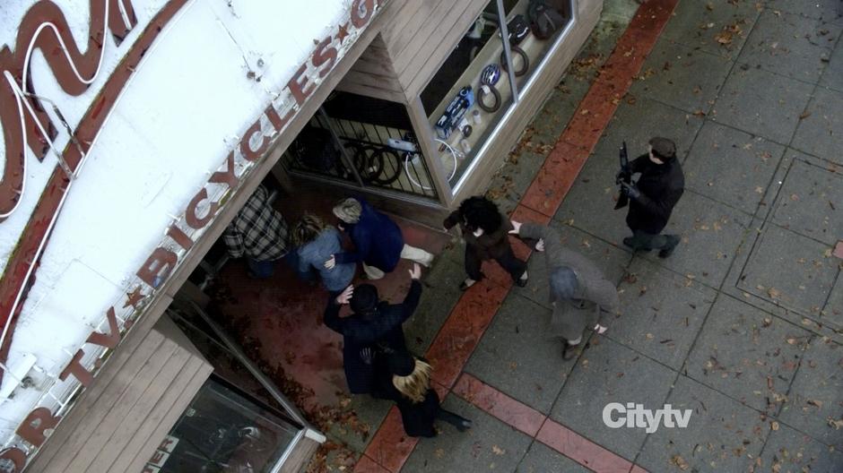 The survivors enter the bicycle shop to escape the collapsing town.