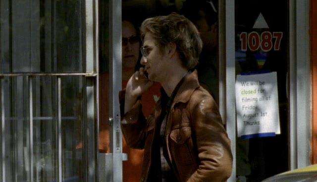 Harrison talks on the phone with Tru. A filming notice can been seen in the background (whoops).