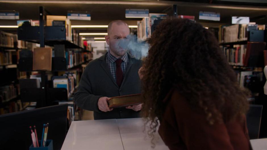 Josefina blows something in the librarian's face so she can borrow the book.