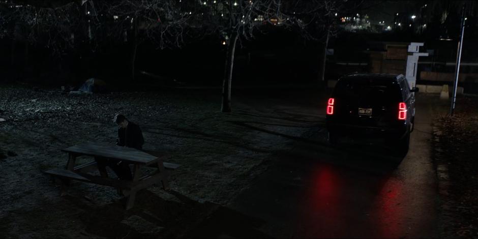 Jacob sits at a picnic table in the park preparing to take the Snakebite.