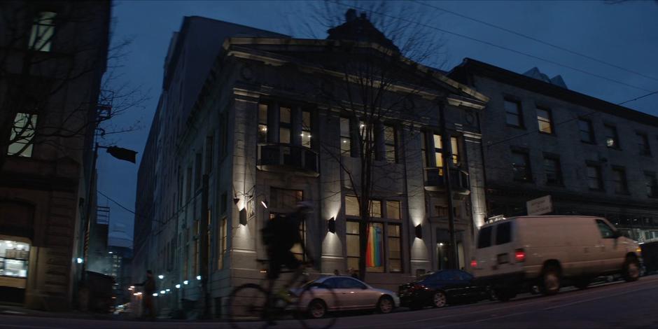 Establishing shot of The Hold Up with a pride flag hanging in the window.