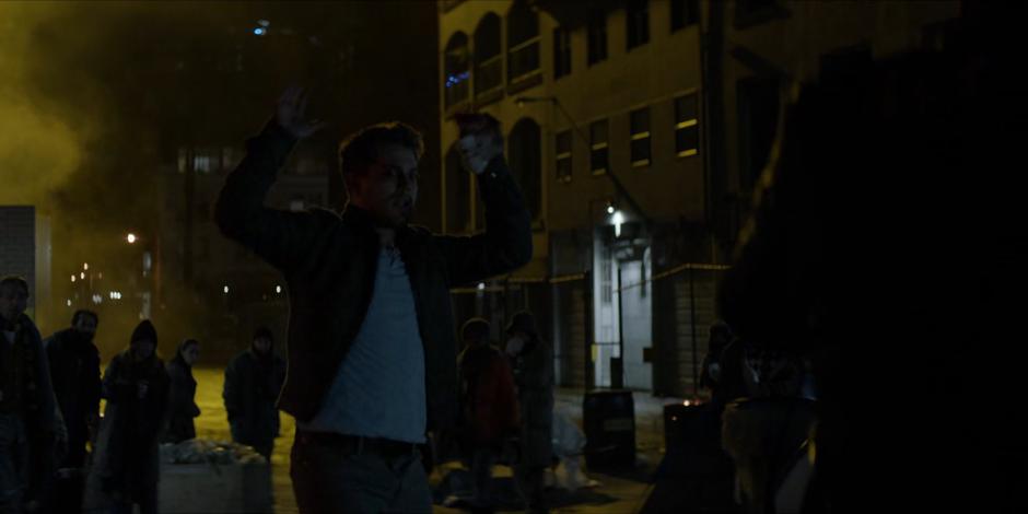 Richard holds up his hands as the cop approaches.