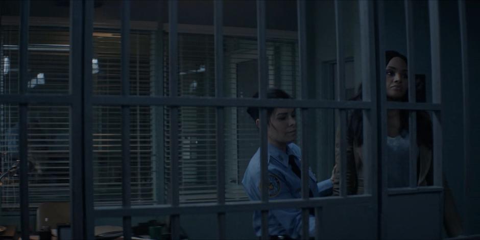 A cop pushes Sophie into the cell with the others.