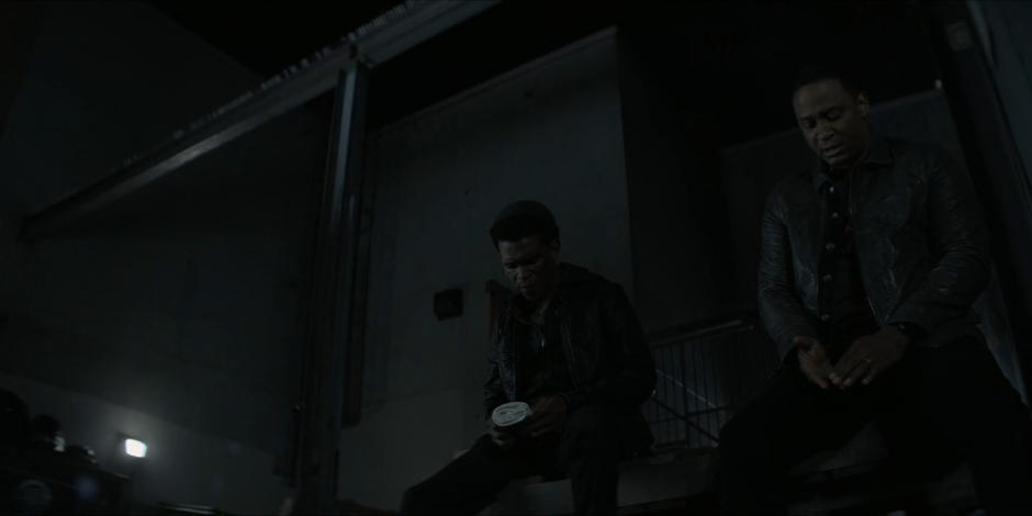 Diggle talks to Luke as they both sit at the side of the alley.