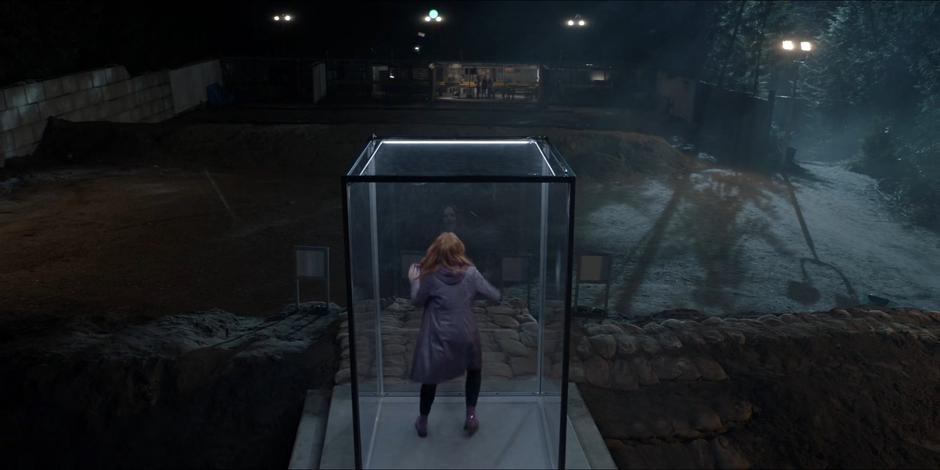 Lights turn on illuminating Stephanie Brown locked in a glass box at the end of the shooting range.