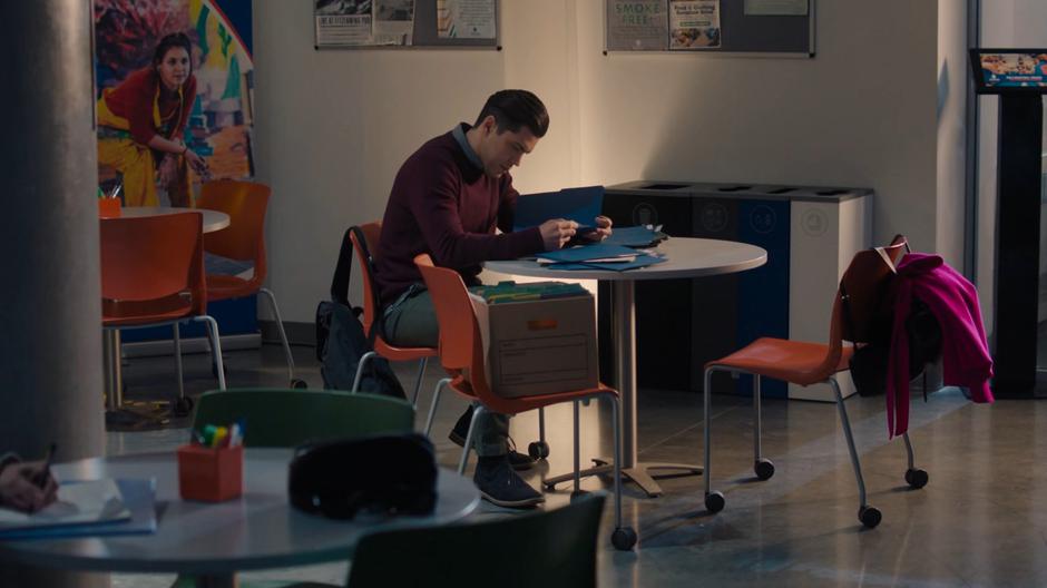 Antonio sits at a table going over research files.