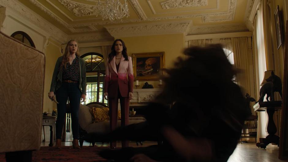 Waverly and Abigael look down at their mother as Macy knocks her unconcious.