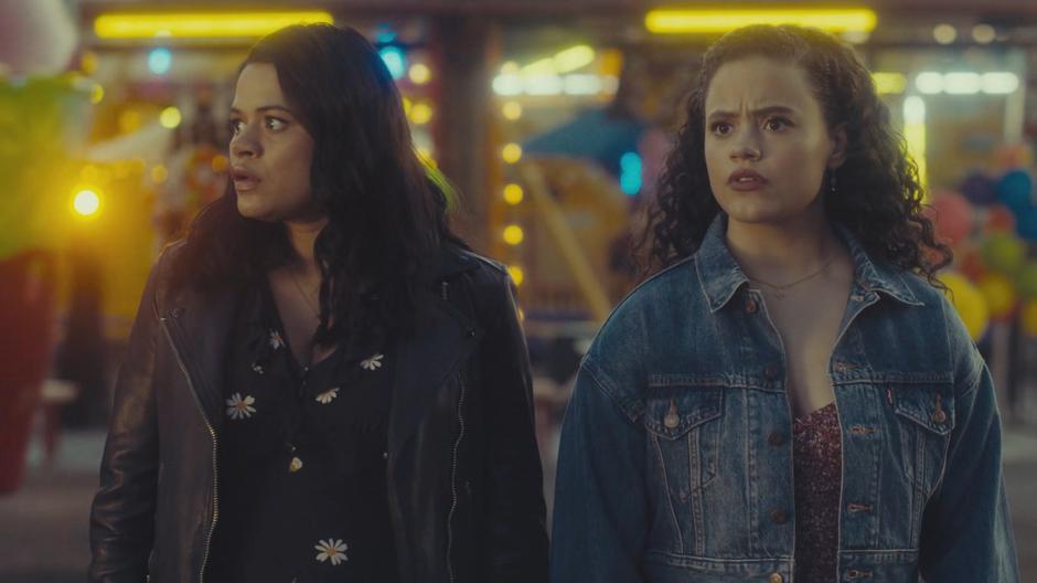 Mel and Maggie look around after appearing in a strange carnival.