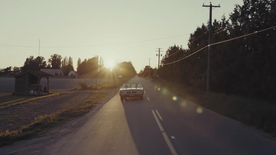 Mel, Maggie, and Macy drive down the road with the sun behind them.