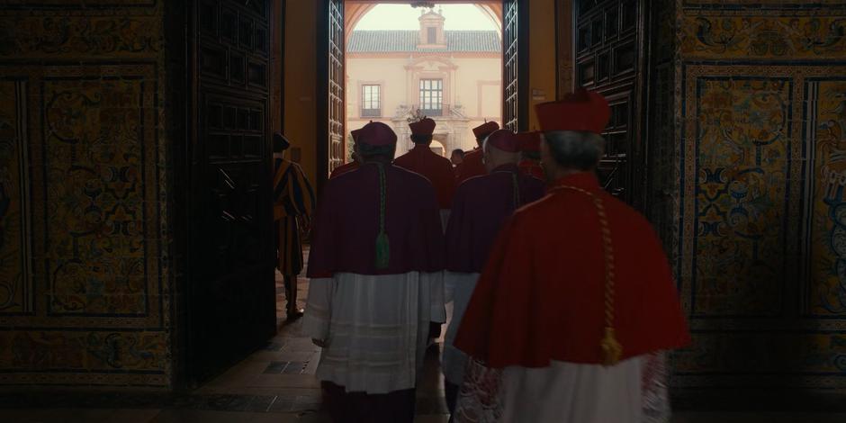 Various bishops and cardinals follow the new pope out into the courtyard.