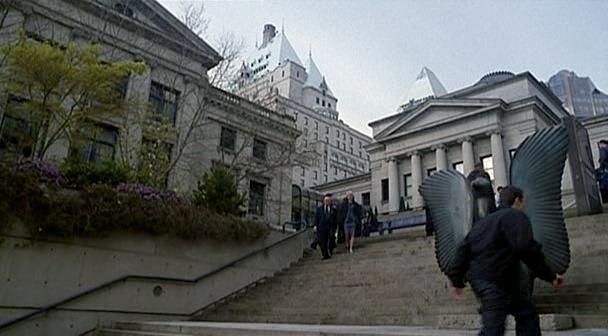 Madame X walks down some steps while talking with someone.