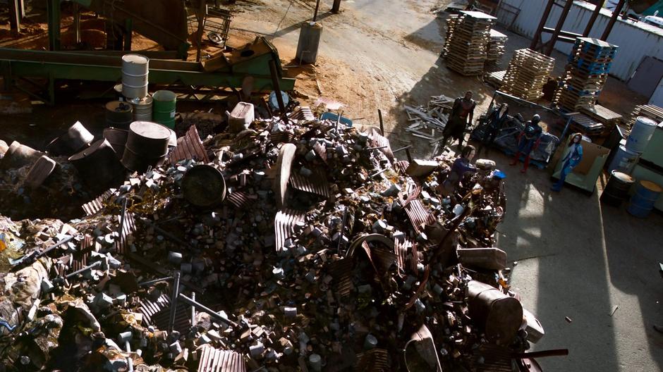 J'onn, Alex, Kara, and Nia watch as Brainy climbs out of the trash pile.