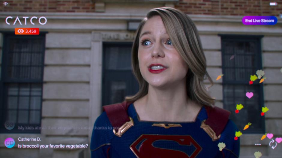 Kara appears awkward on camera for the livestream as Supergirl.