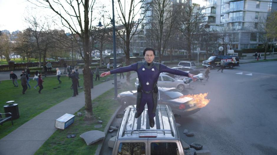 Brainy leaps off the top of a car as Kara distracts the car.