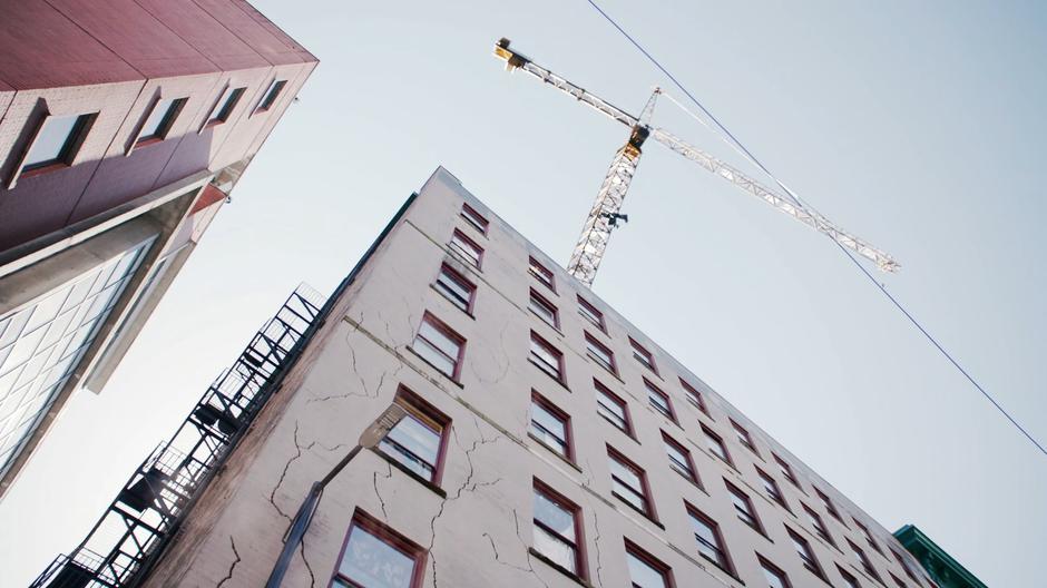 J'onn flies up to stop a crane from collapsing.