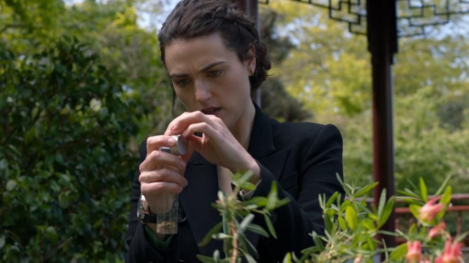 Lena prepares the plants and other components she needs for the spell in a small vial.