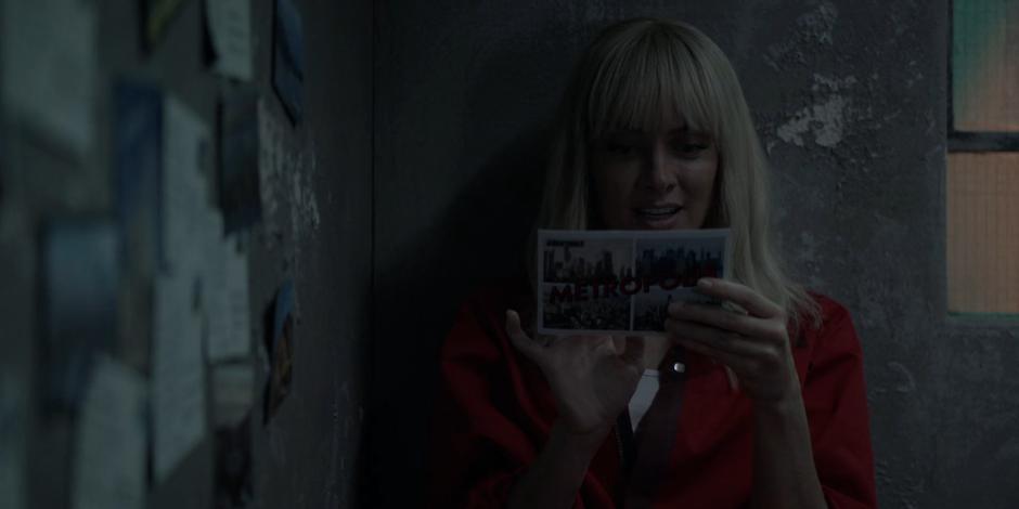 Alice sits in her cell reading one of the postcards she received from her father.