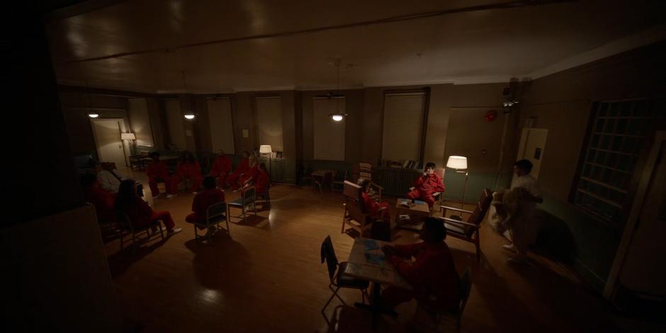 Alice and other inmates sit in a group therapy session.