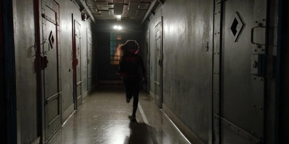 Ryan races down the hallway after Alice who has returned to her cell.