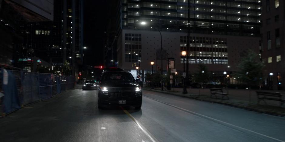 The Batmobile follows close behind one of the mercenaries' vehicles.