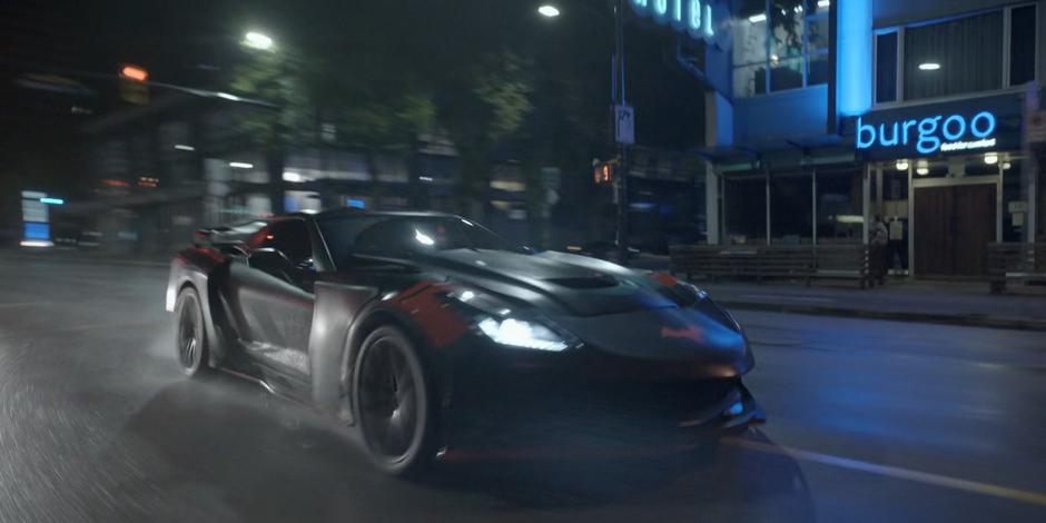 The Batmobile races down the street at night after the mercenaries.